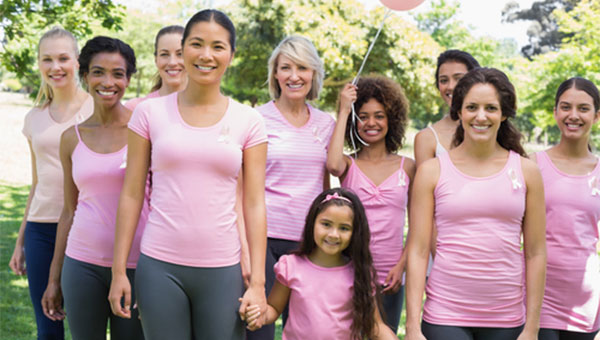 A group of women and girls are wearing pink shirts for breast cancer awareness month.