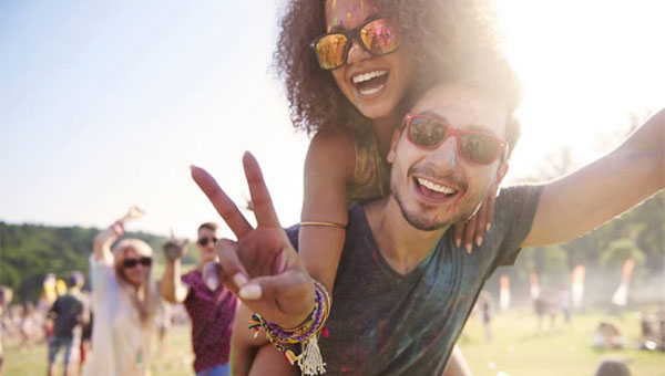 A young woman and man are enjoying the outdoors at a festival.