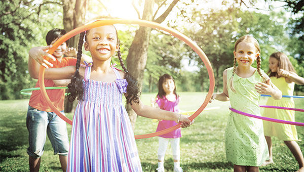 A group of girls is playing with hula hoops outside