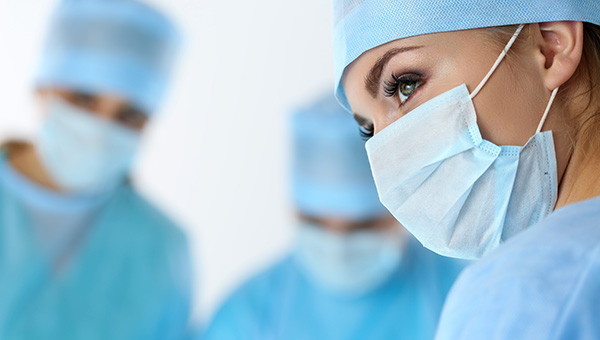 A female surgeon stands near her colleagues