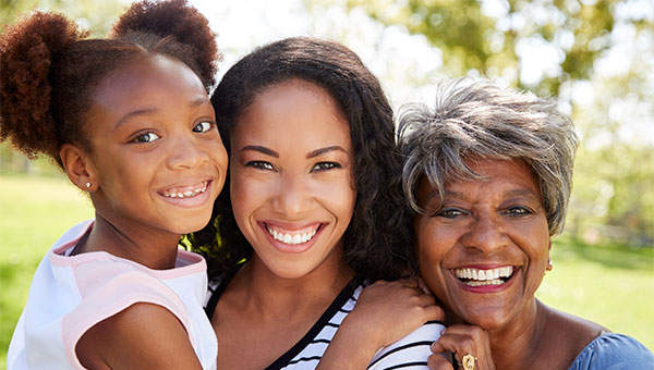 Three generations of women smiling and hugging each other