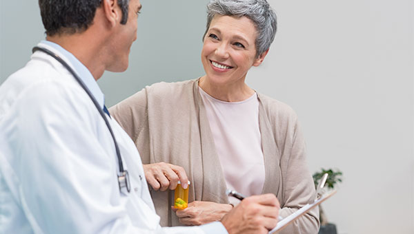 A female patient gets a prescription from a male doctor.