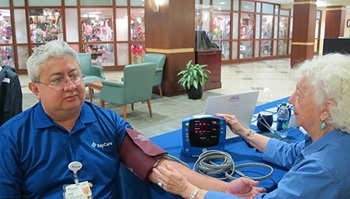 A senior man is getting a blood pressure screening at a BayCare event.