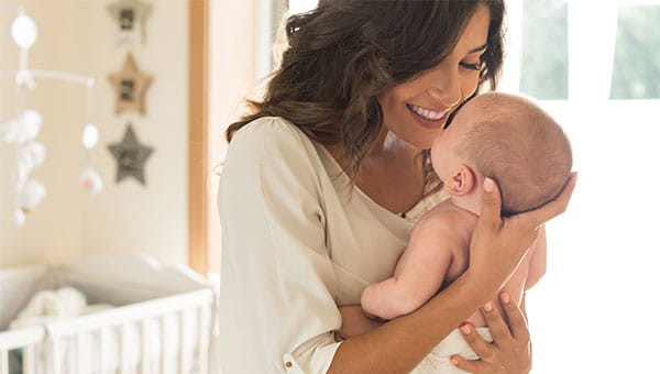 A young mother is holding her newborn baby.