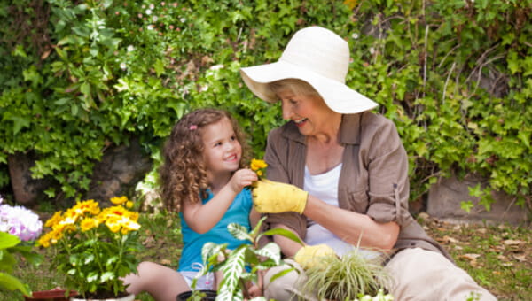 Happy Grandmother with her granddaughter working in the garden