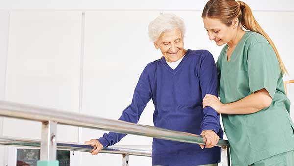 A physical therapist assists a senior patient with her rehabilitation.