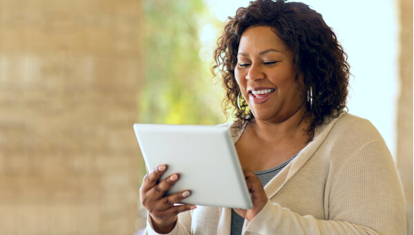 a smiling woman using her tablet