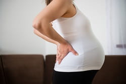 A pregnant woman has pain in her lower back.