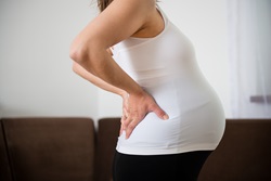 A pregnant woman has pain in her lower back.