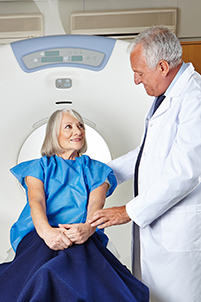 A male doctor talks with a senior female patient before a radiation therapy procedure.
