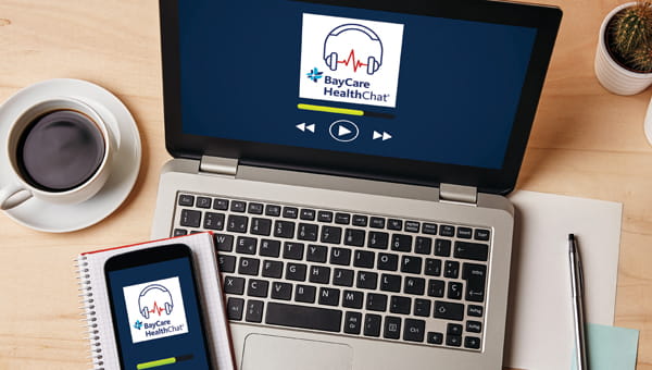 BayCare HealthChat podcast logo displayed on a laptop and cell phone with a cup of coffee nearby.