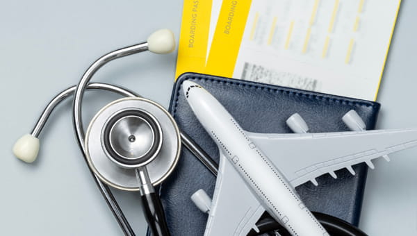 A model airplane, and stethoscope, and a pair of airline tickets
