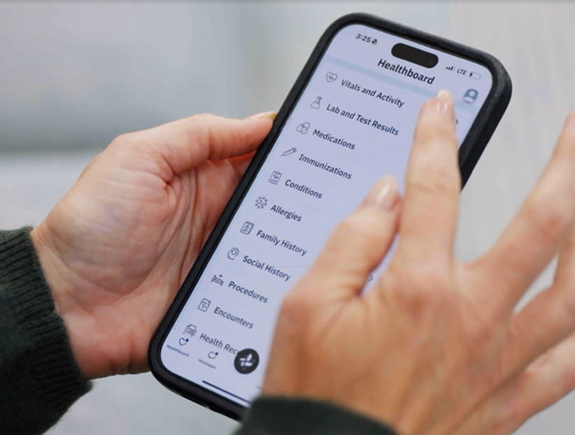 A pair of hands scrolling through the patient app.