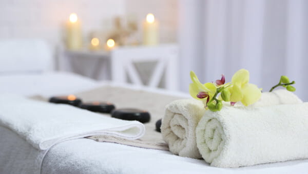 A massage therapy table with towels and stones on it