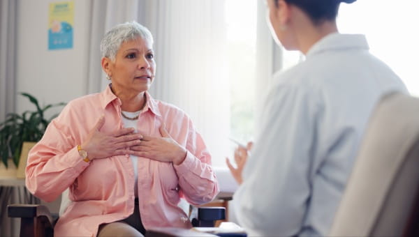 A woman consults with a doctor about her arrhythmia, discussing symptoms and treatment options in a medical setting.