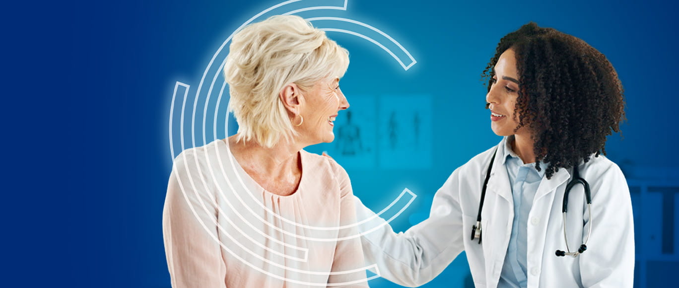 Woman doctor smiling and comforting an older woman patient