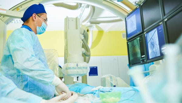 A surgeon performs a heart procedure.