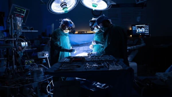 Three surgeons performing open-heart surgery