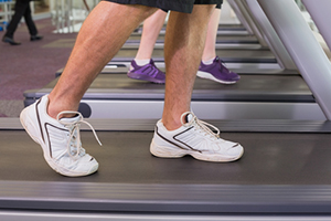 A senior male walks on a treadmill.
