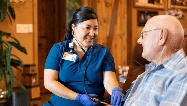 A female BayCare employee working with an older male in a home care setting.