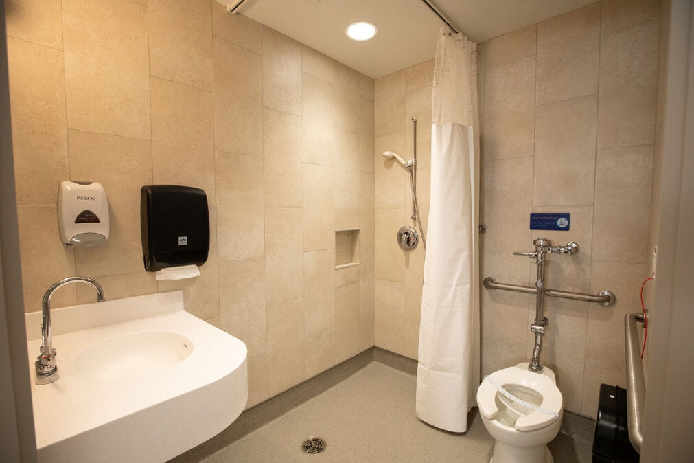 a private bathroom in a NICU room with a private toilet, sink, and standing shower