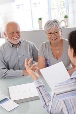 A senior couple is meeting with a female doctor.