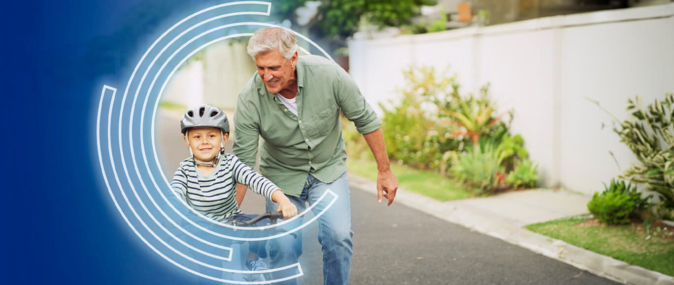 A man pushes a child on a bicycle inside the BayCare Effect rings.