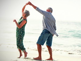 A senior couple dancing on the beach