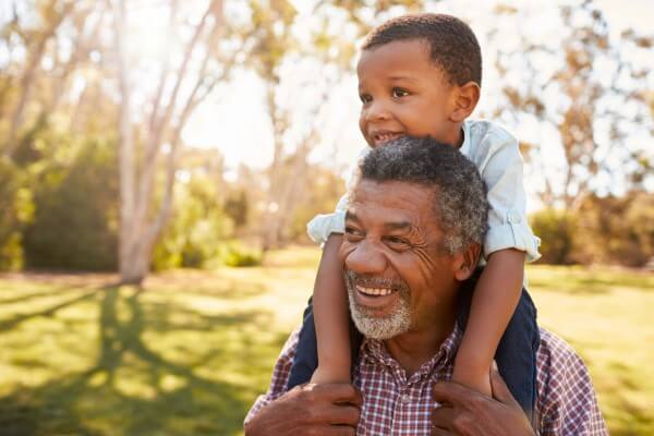 man holding his grandson on his shoulders