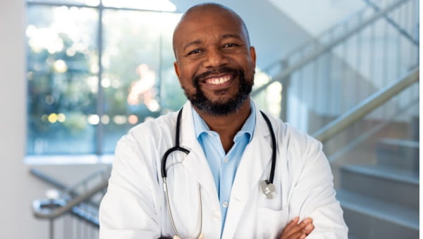 smiling male doctor posing for a photo on an interior staircase