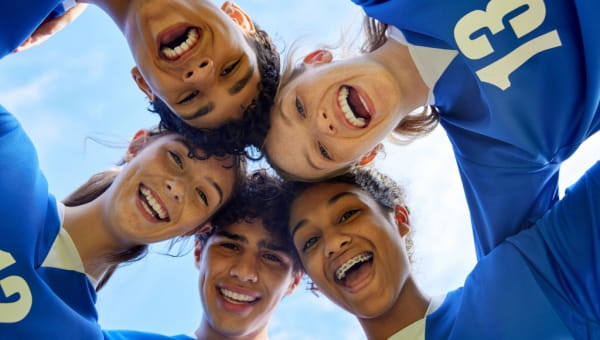 group of soccer players in a scrum smiling