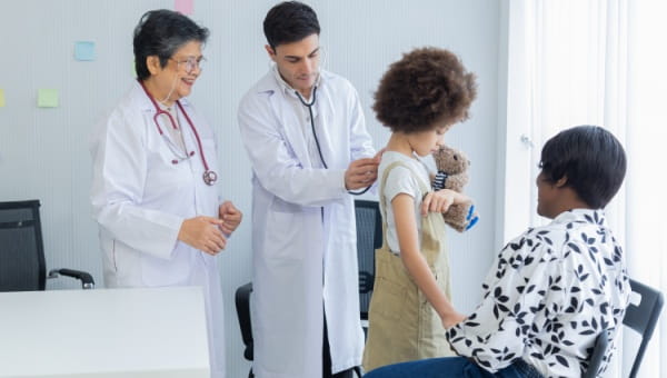 A pediatric patient being examined by two doctors