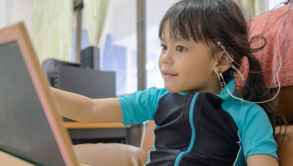 A little girl, who is a pediatric patient is connected to an EEG machine for neurodiagnostic testing