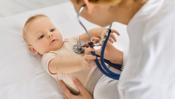 Baby being examined by a pediatric primary care provider with a stethoscope