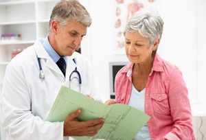 A doctor and a senior woman look over a medical report