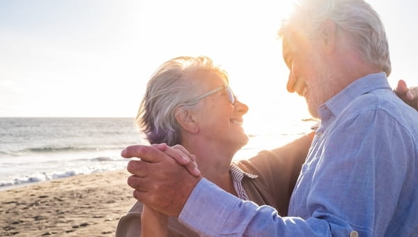man and woman holding hands at beach