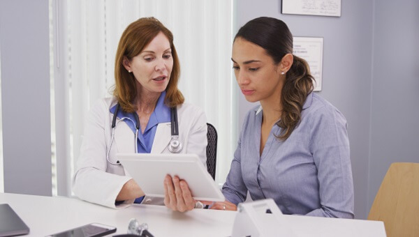 female doctor explaining chart to young female patient