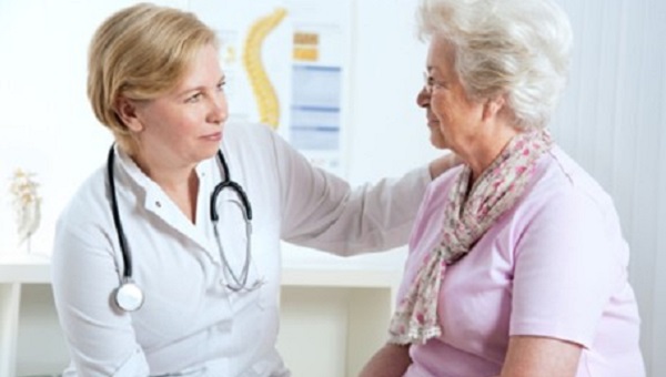 female doctor putting her arm on elderly female patient
