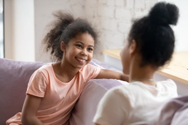 Two young girls talking with one another